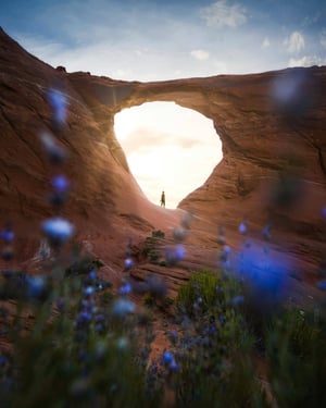 Person standing in crevice of rock formation